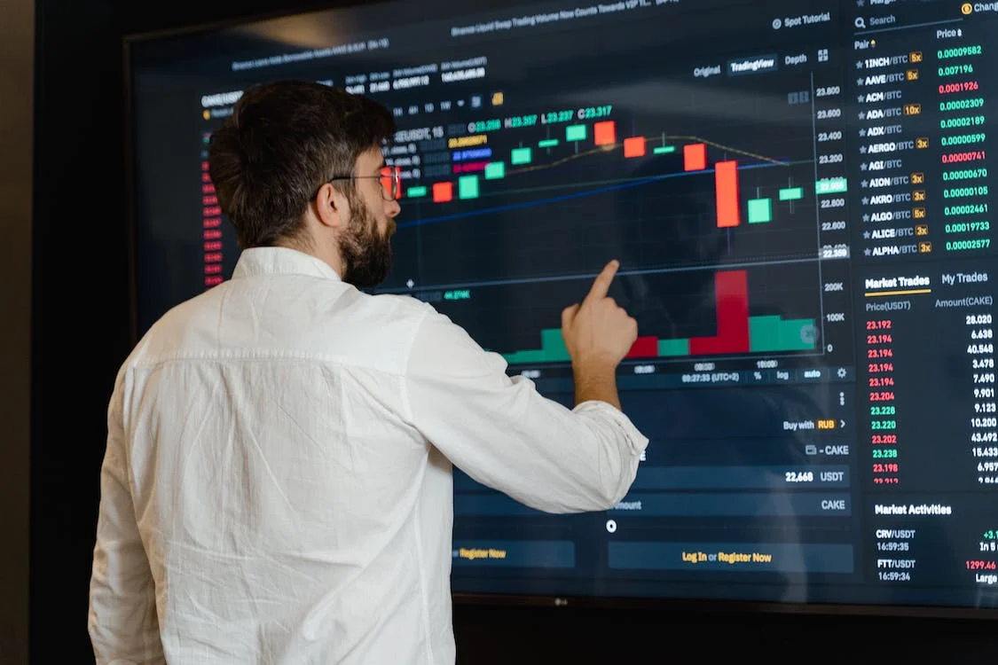 person holding smartphone with stock data and trends
