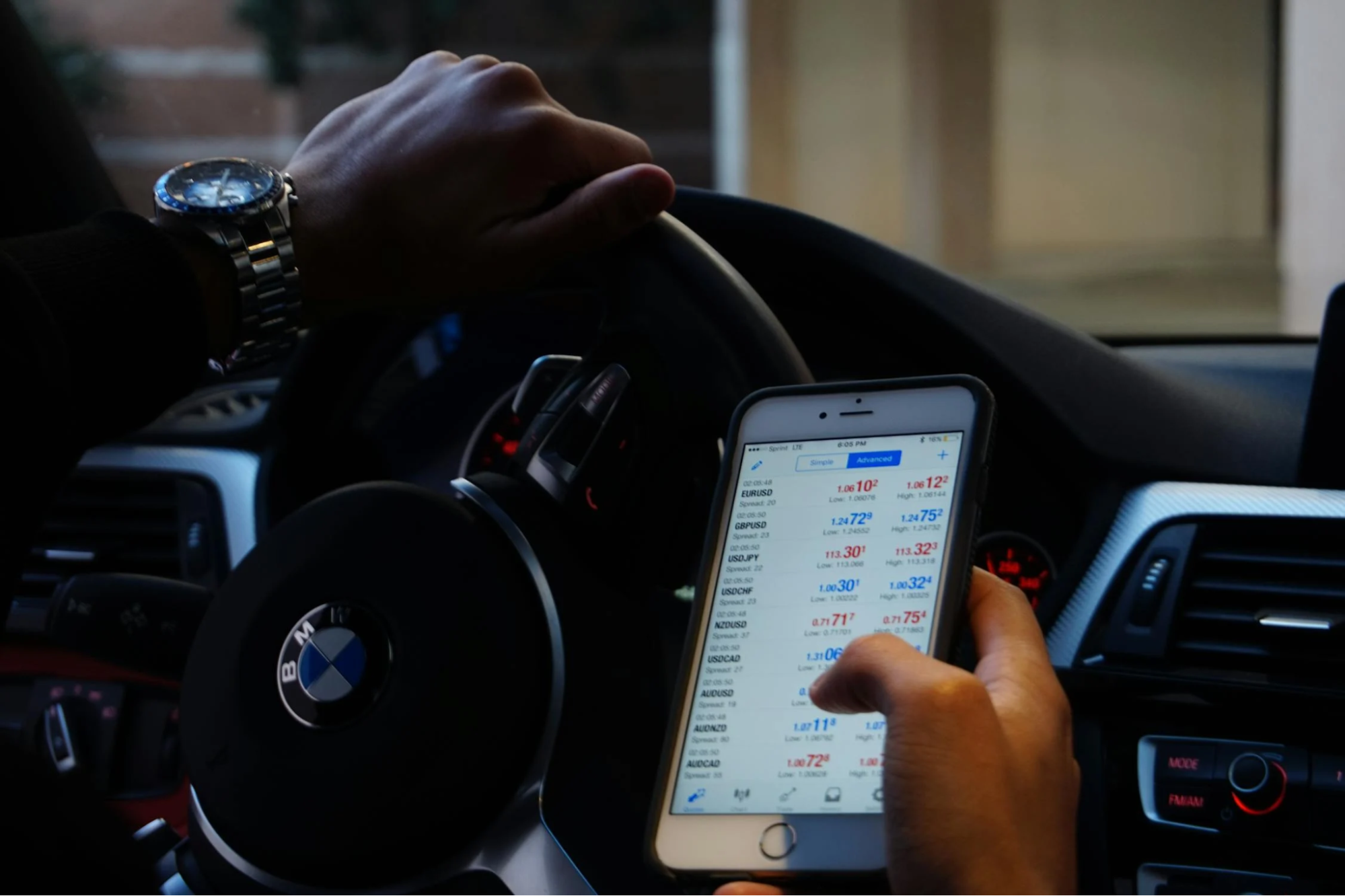 unseen man holding phone checking trading data