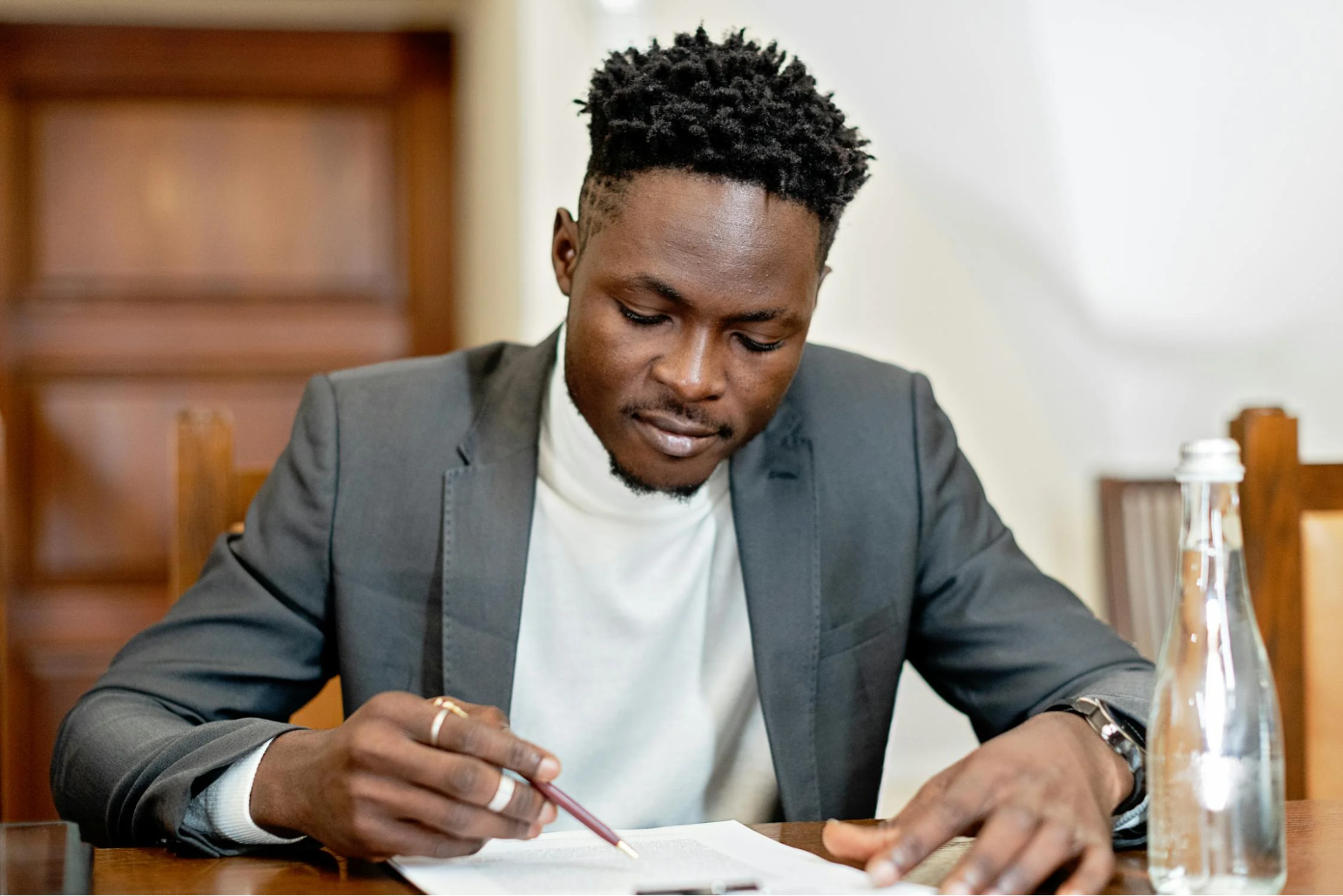 man in gray suit jacket holding pen