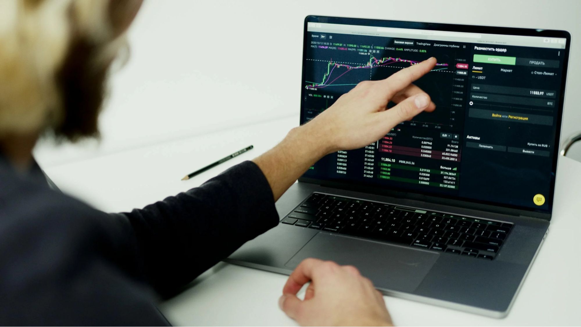 Person Analyzing Stock Market Graphs on Laptop Screen